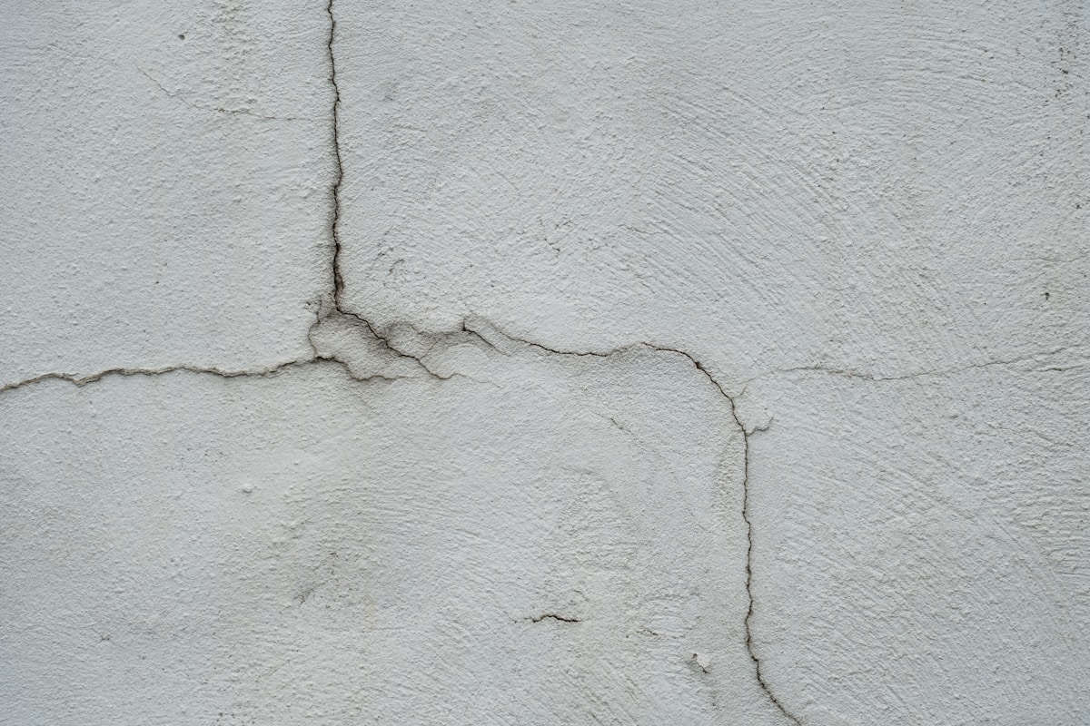 Mur de béton gris avec des fissures profondes.