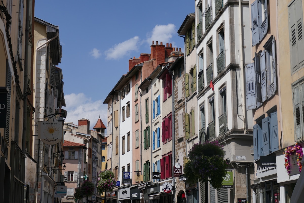 Rues étroites, bâtiments colorés, commerces, ciel bleu, architecture européenne.