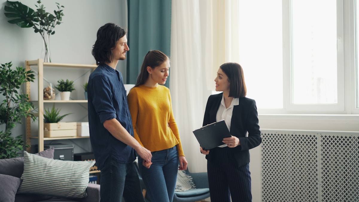 Trois personnes discutant dans un intérieur moderne et lumineux.
