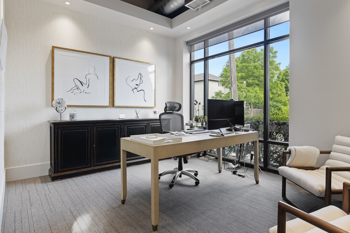 Bureau moderne avec œuvres d'art, fenêtres panoramiques et mobilier élégant.
