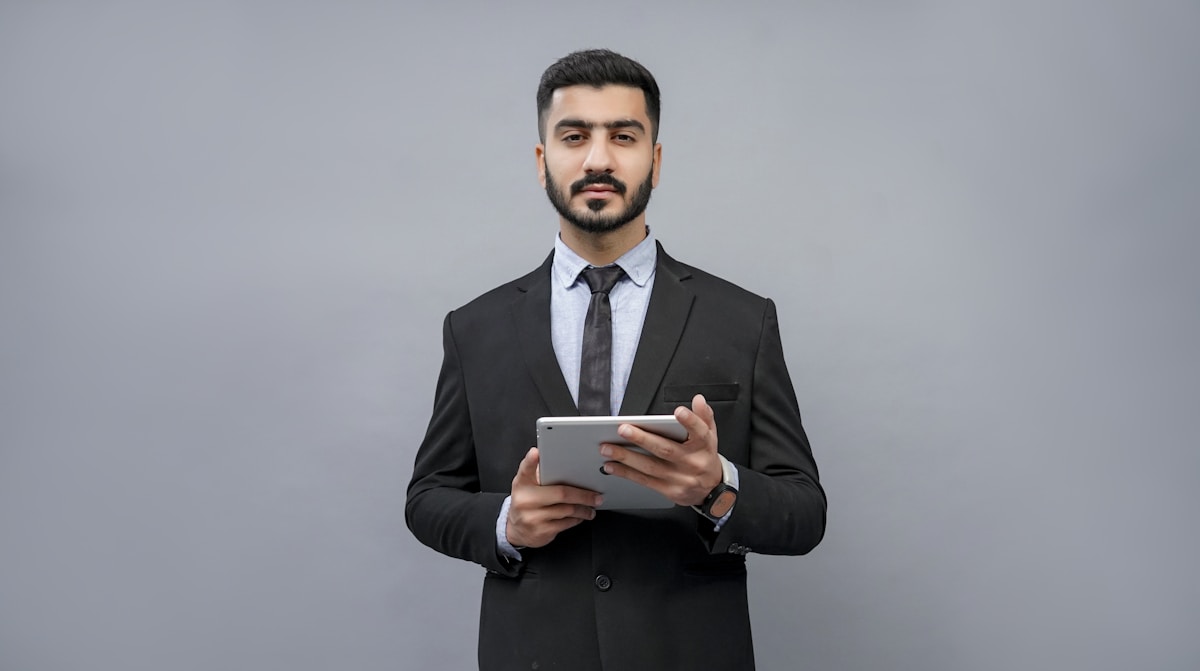 Homme d'affaires en costume tenant une tablette numérique.
