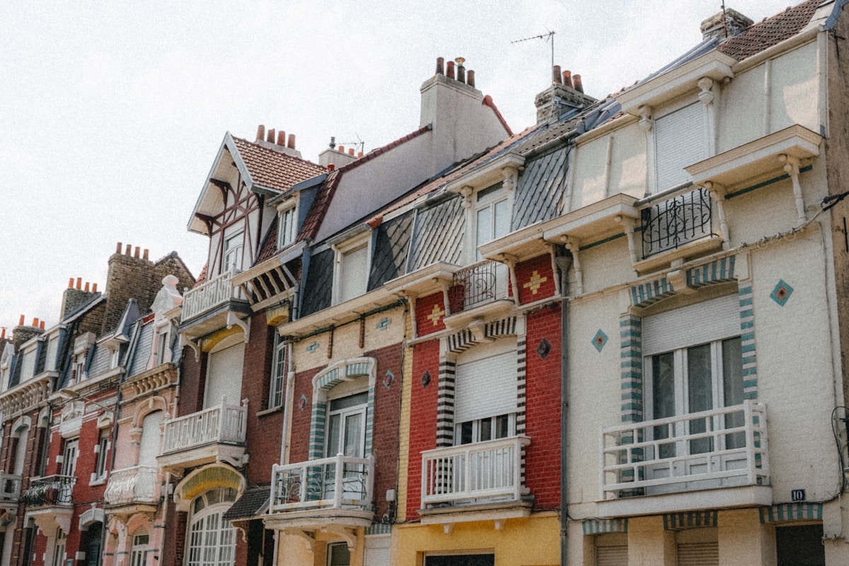 Façades colorées de maisons anciennes avec balcons et décorations.