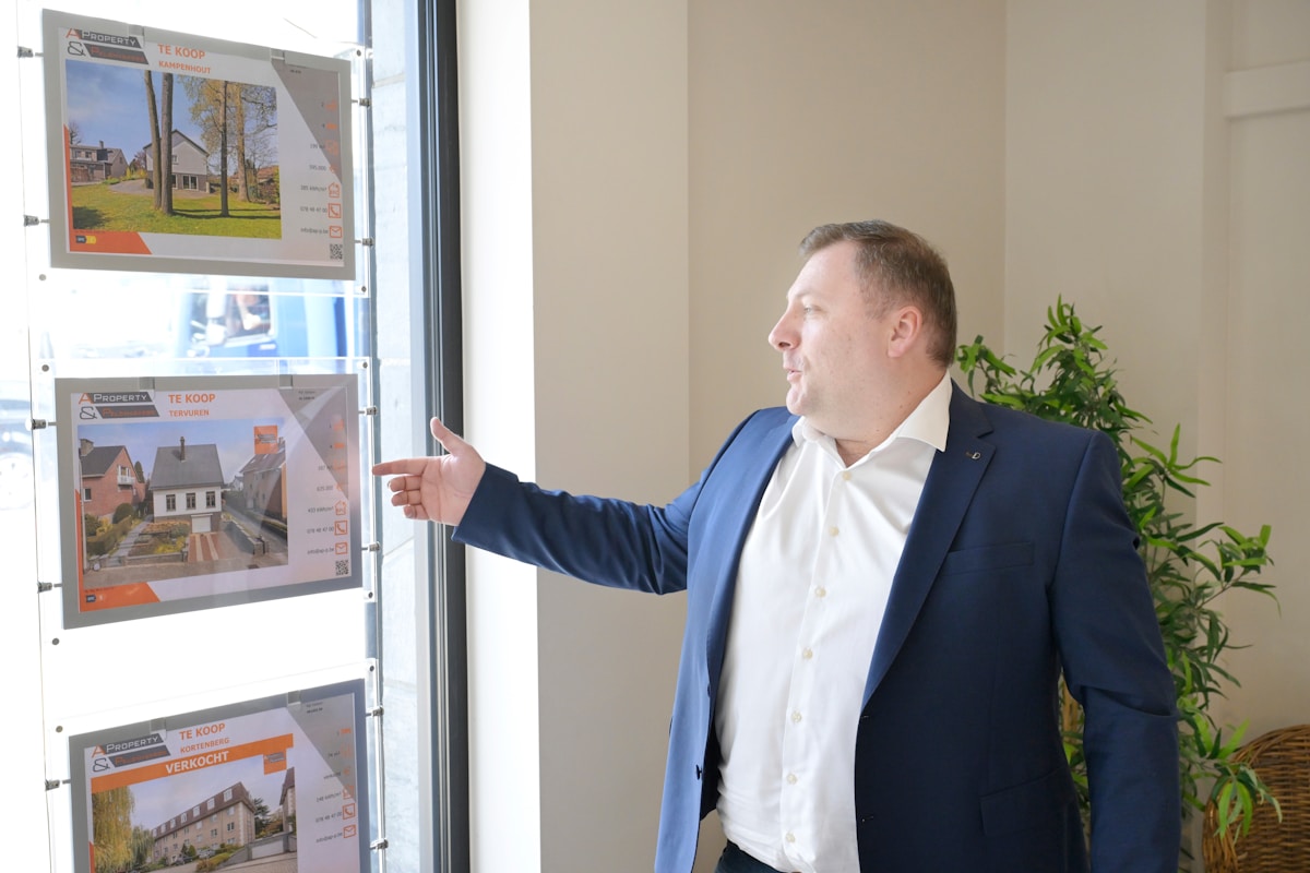 Un agent immobilier présentant des propriétés à vendre dans une vitrine.