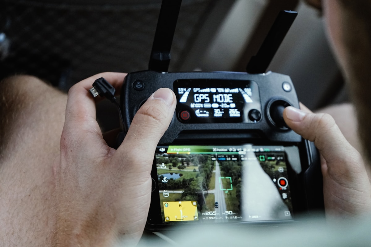 Contrôleur de drone avec écran affichant des données GPS.