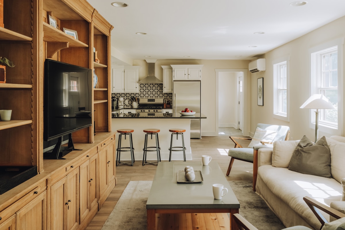 Intérieur moderne et lumineux avec cuisine ouverte et mobilier en bois.