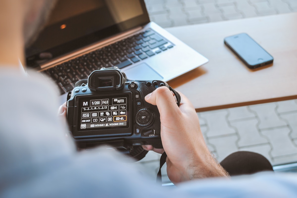 Appareil photo numérique professionnel sur un bureau avec un ordinateur portable.
