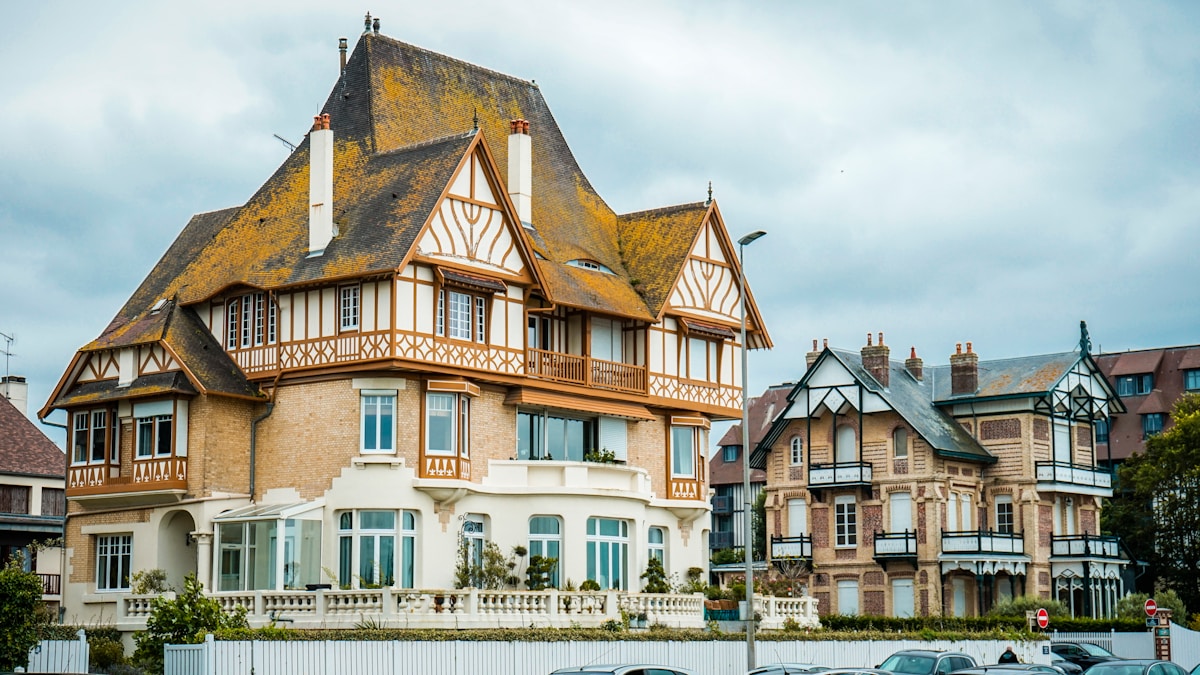 Maison de style architectural traditionnel français avec toits en pente et façade en bois.