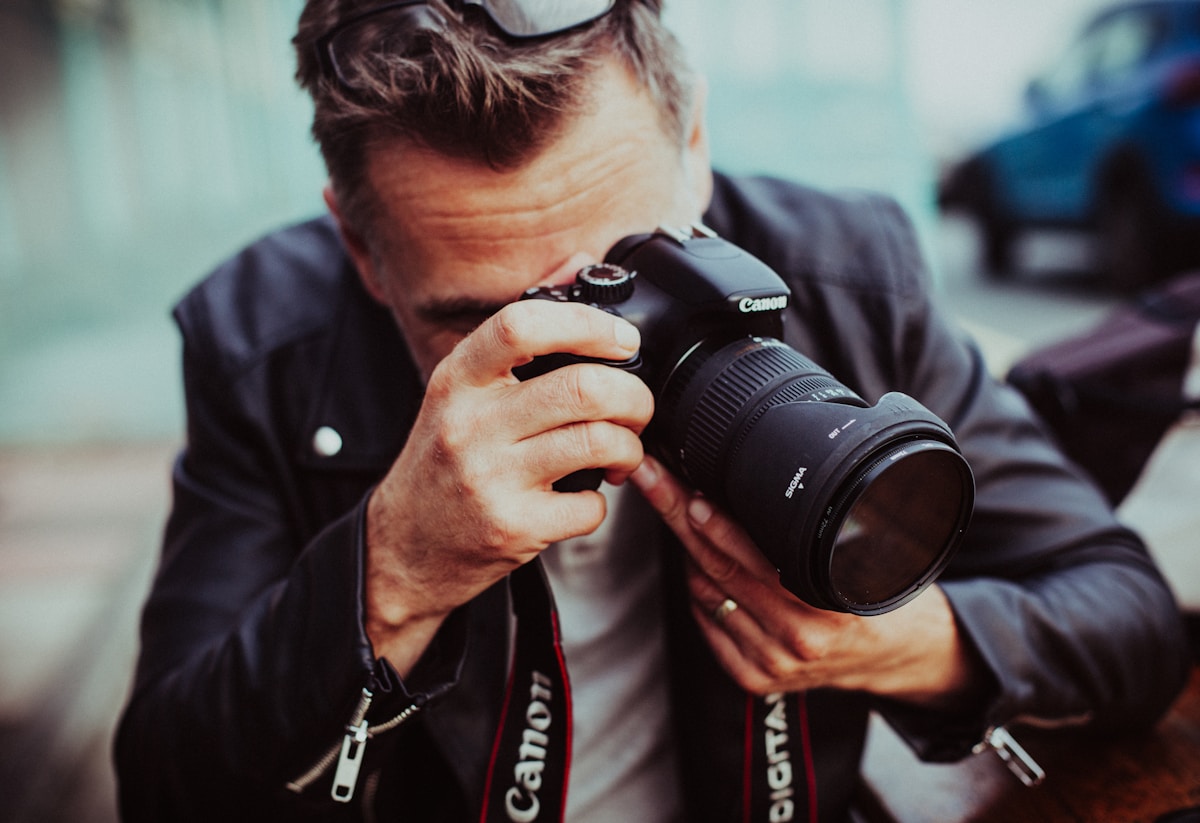 Homme photographiant avec un appareil photo Canon.