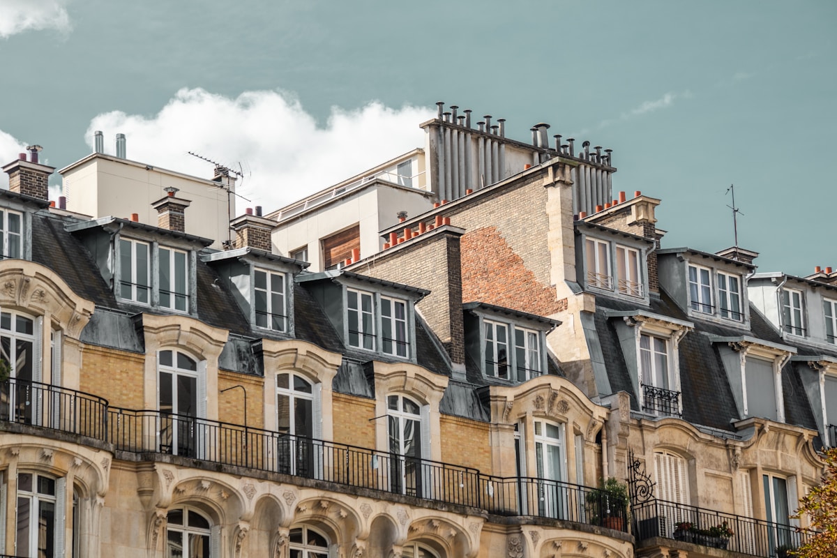Bâtiments anciens à Paris avec toits en ardoise et fenêtres ornées.