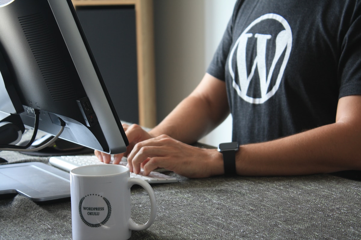 Développeur WordPress travaillant sur un ordinateur avec une tasse.