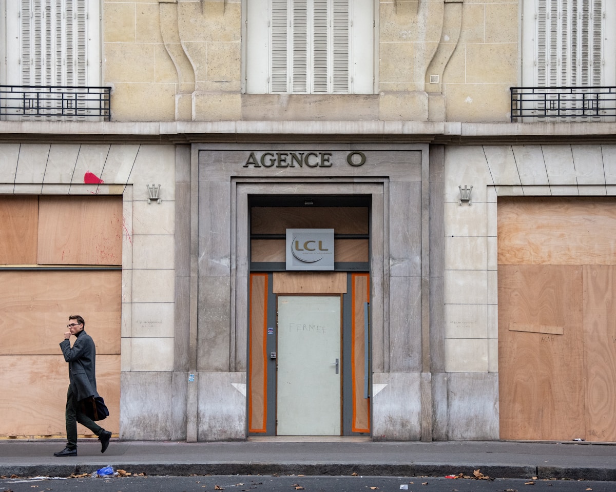 Bâtiment d'agence bancaire LCL avec homme passant devant.