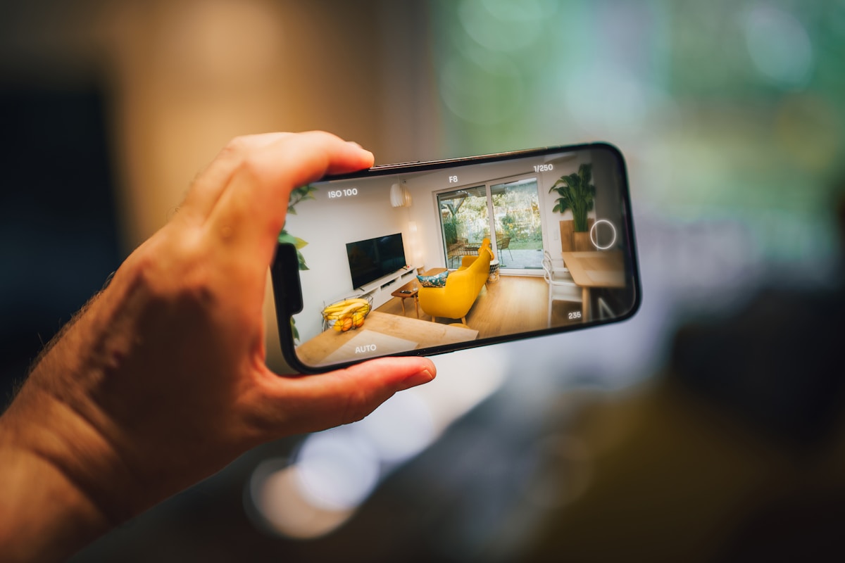 Smartphone montrant une pièce meublée avec un canapé jaune.