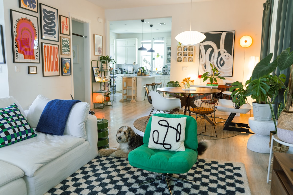 Intérieur coloré et éclectique avec canapé, chien et décorations murales.