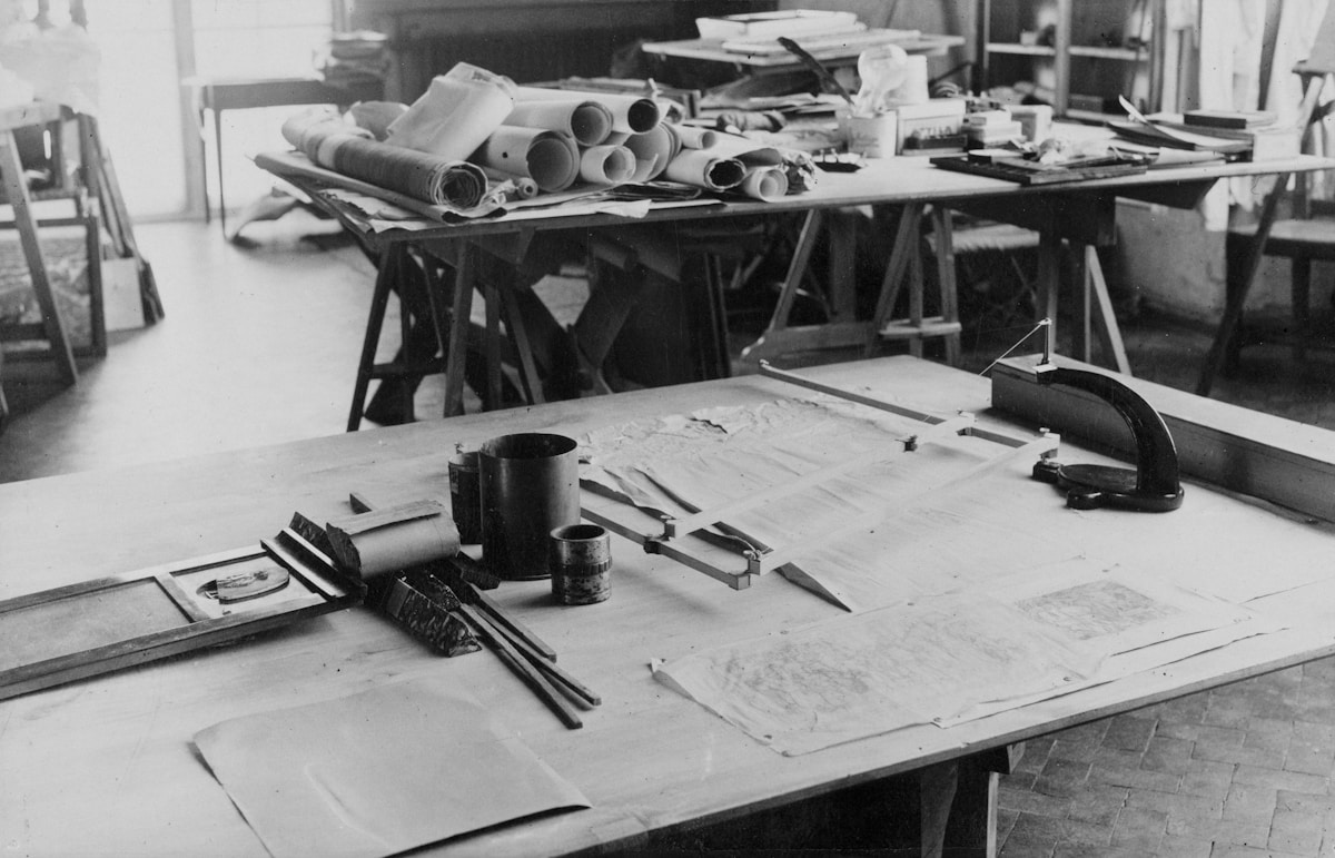 Atelier d'artiste encombré avec outils et matériaux.