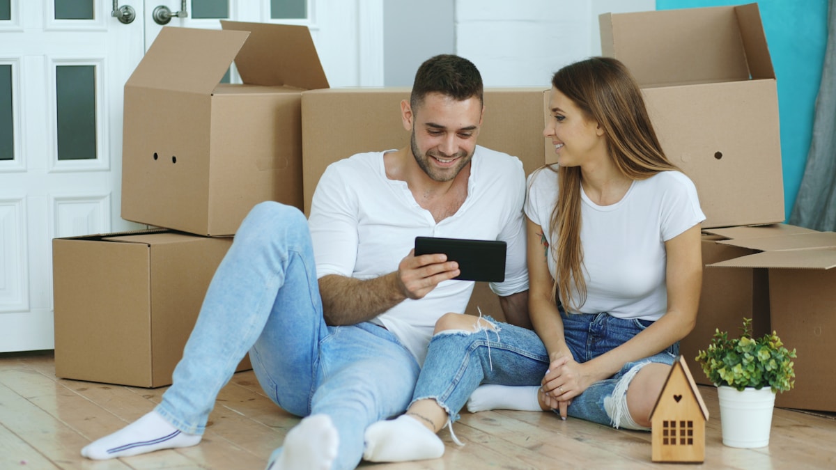 Couple heureux déballant leurs affaires dans leur nouveau logement.