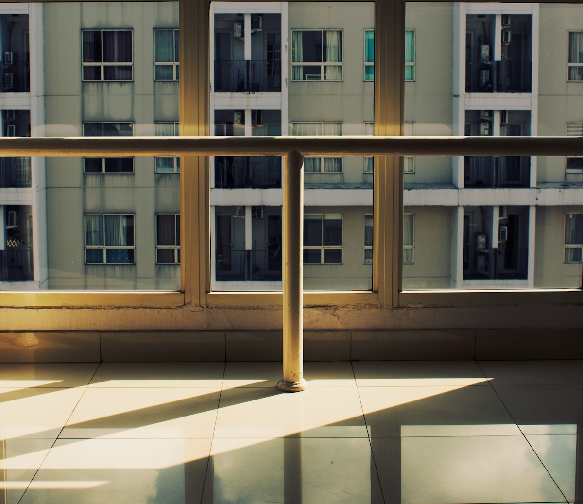 Immeuble de bureaux avec reflets sur le sol carrelé.