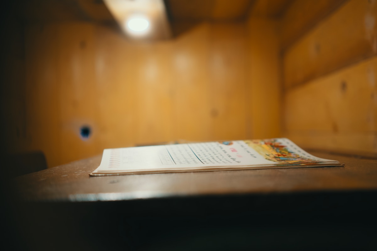 Livre ouvert sur une table dans une pièce sombre.