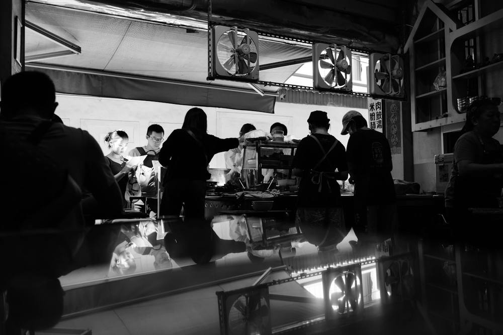 Des personnes en silhouette rassemblées autour d'un bar.