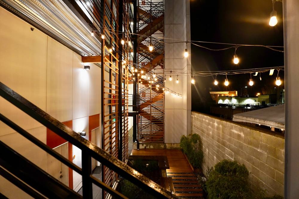 Un escalier avec des lumières suspendues, à côté d'un bâtiment.