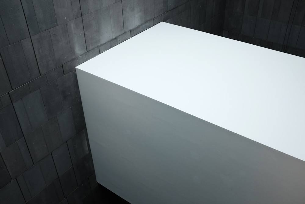 Table en bois blanc sur carrelage blanc.