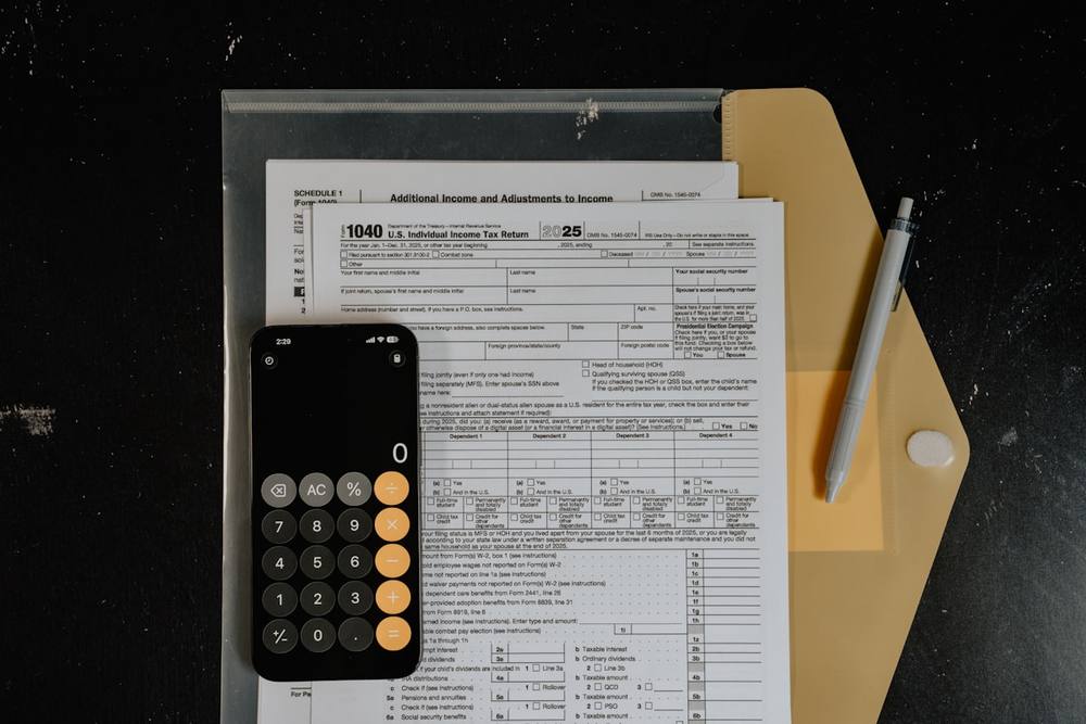 Calculatrice et stylo sur des formulaires fiscaux
