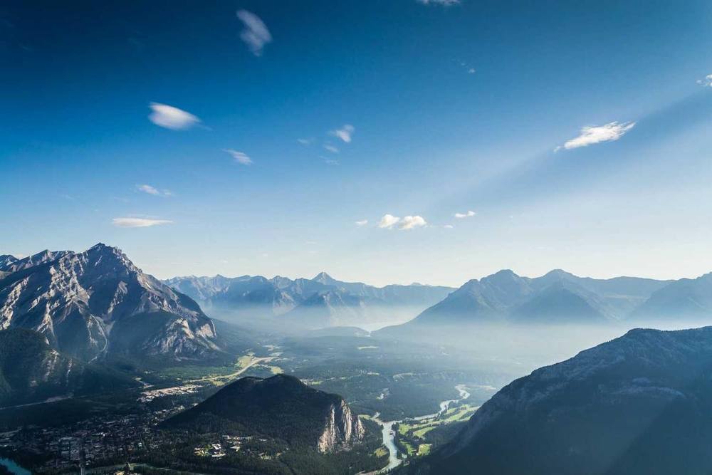 Chaîne de montagnes surplombant une vallée avec une rivière et une ville.