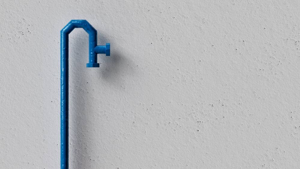Une poignée bleue sur un mur blanc.