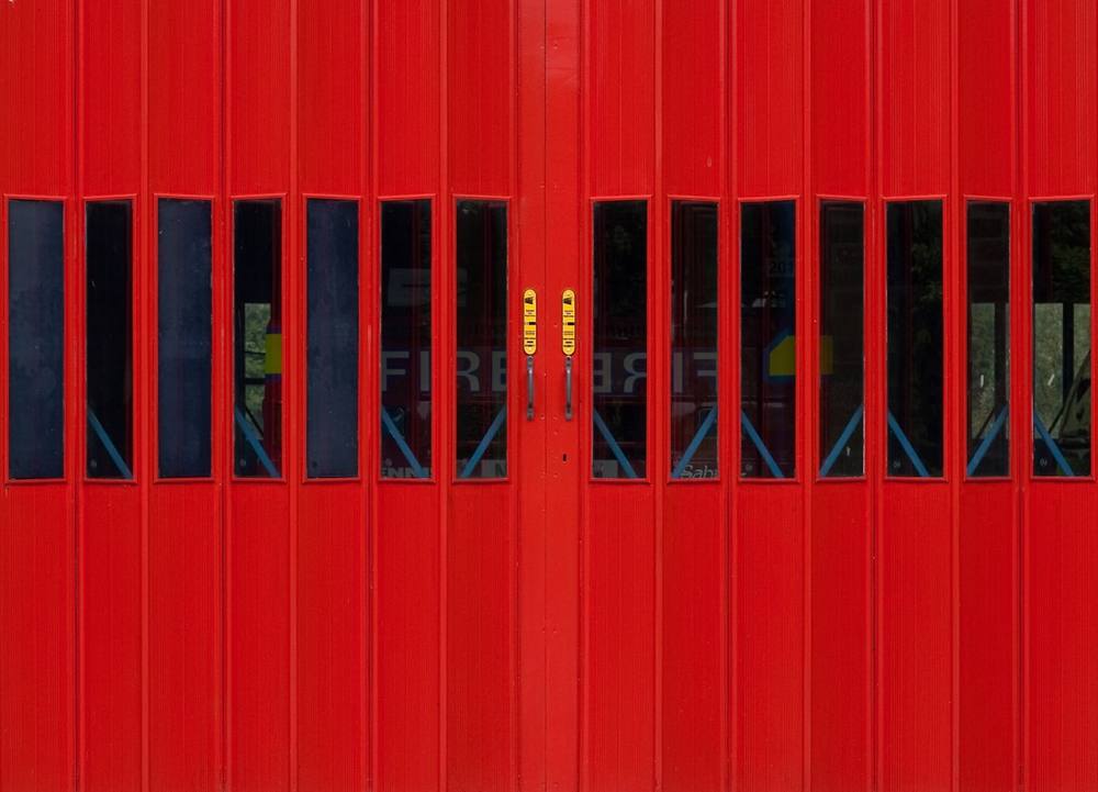 Panneaux rouges verticaux avec fenêtres noires et deux signaux jaunes.