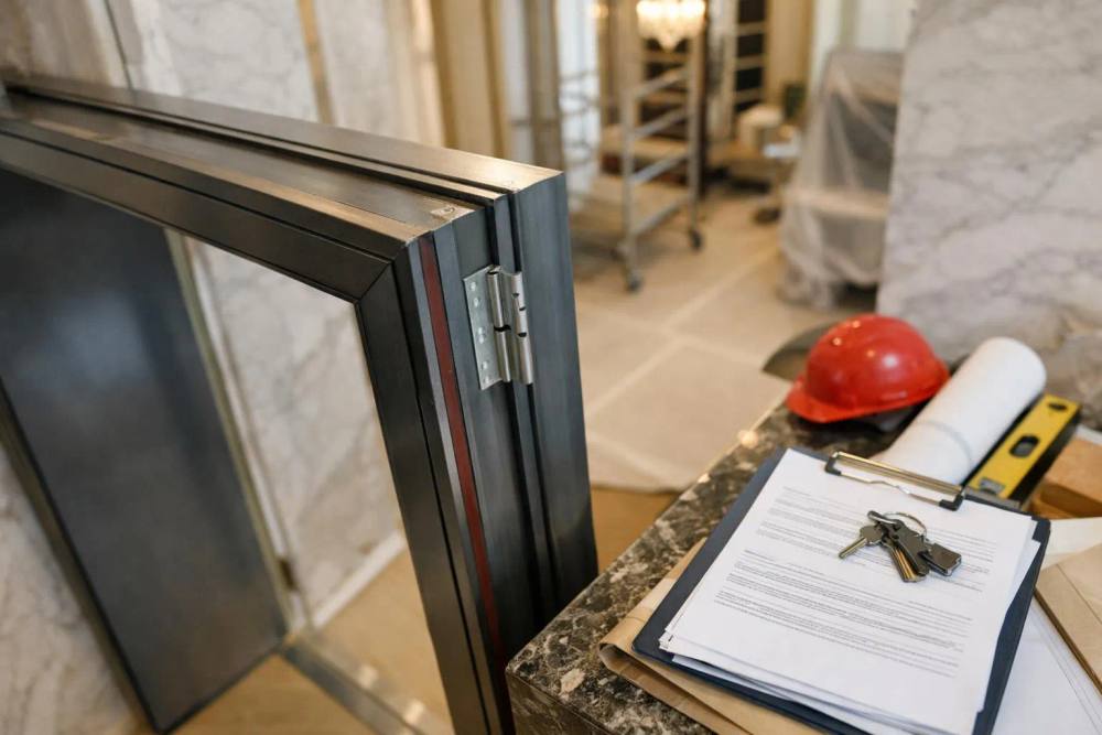 Cadre de porte en métal, outils de construction, documents sur le comptoir.