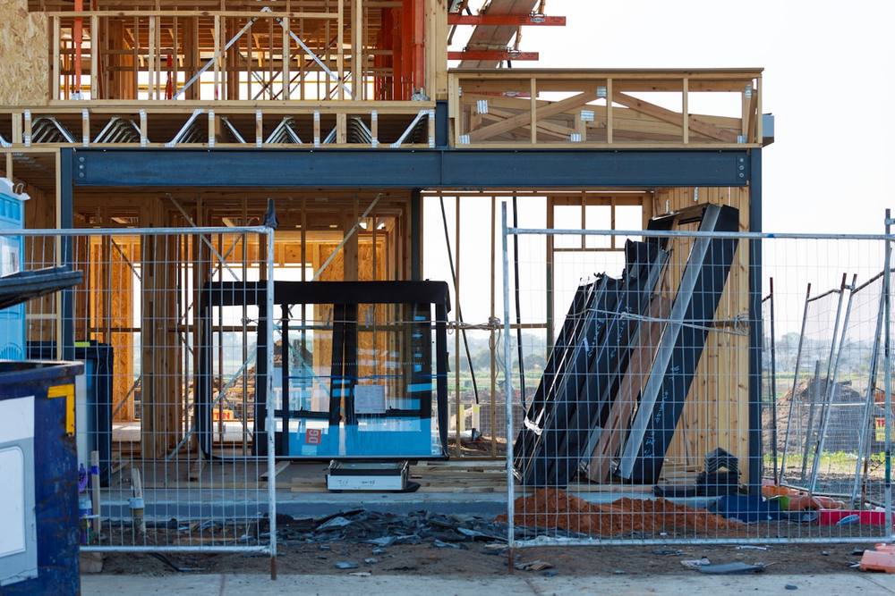 Chantier de construction en bois avec échafaudages et équipements.