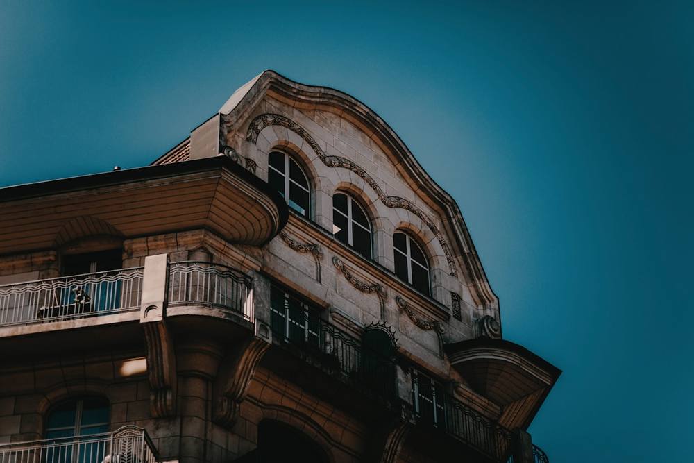Bâtiment ancien à l'architecture ornementée, contre un ciel bleu vif.