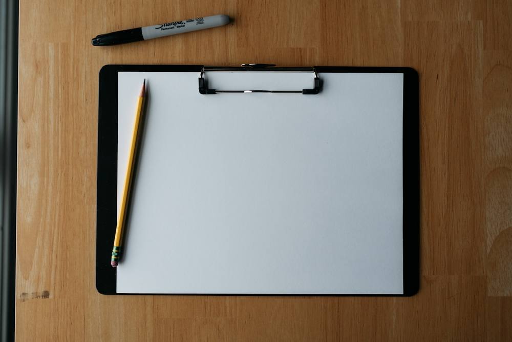 Bloc-notes avec crayon et marqueur sur une surface en bois.