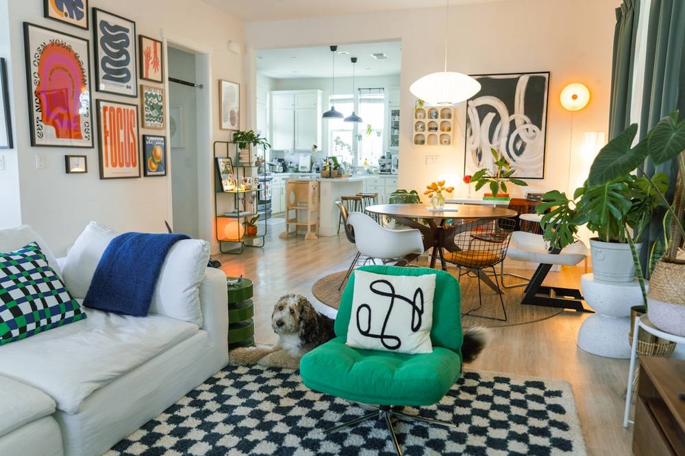 Intérieur coloré et éclectique avec canapé, chien et décoration murale.