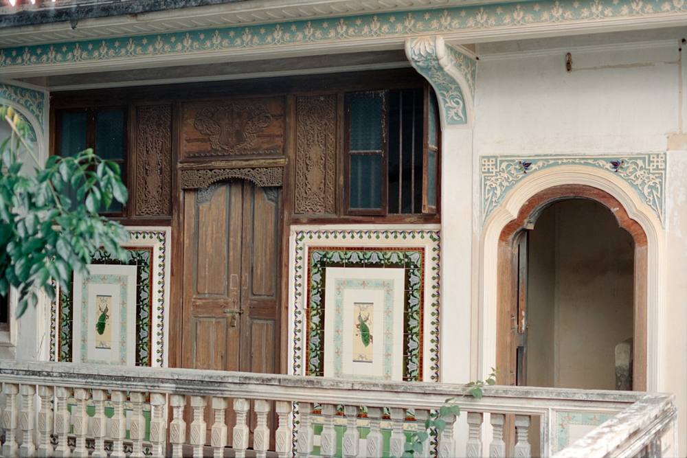 Un balcon orné de panneaux carrelés et d'une porte en bois.