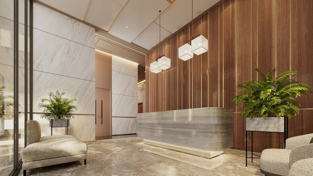 Lobby moderne avec un comptoir d'accueil en marbre et des plantes.