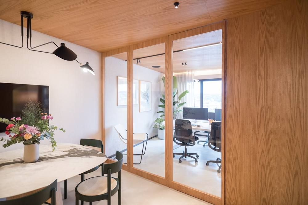 Espace de travail moderne avec meubles en bois et plantes.