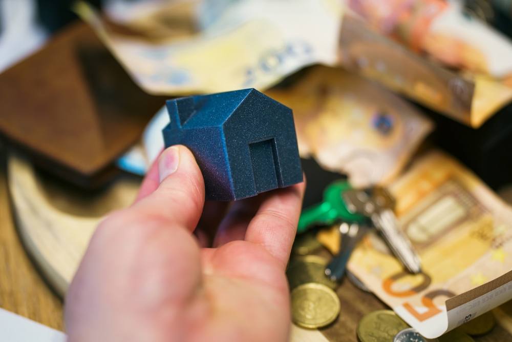 Acheter une maison avec de l'argent, des clés et des pièces de monnaie.