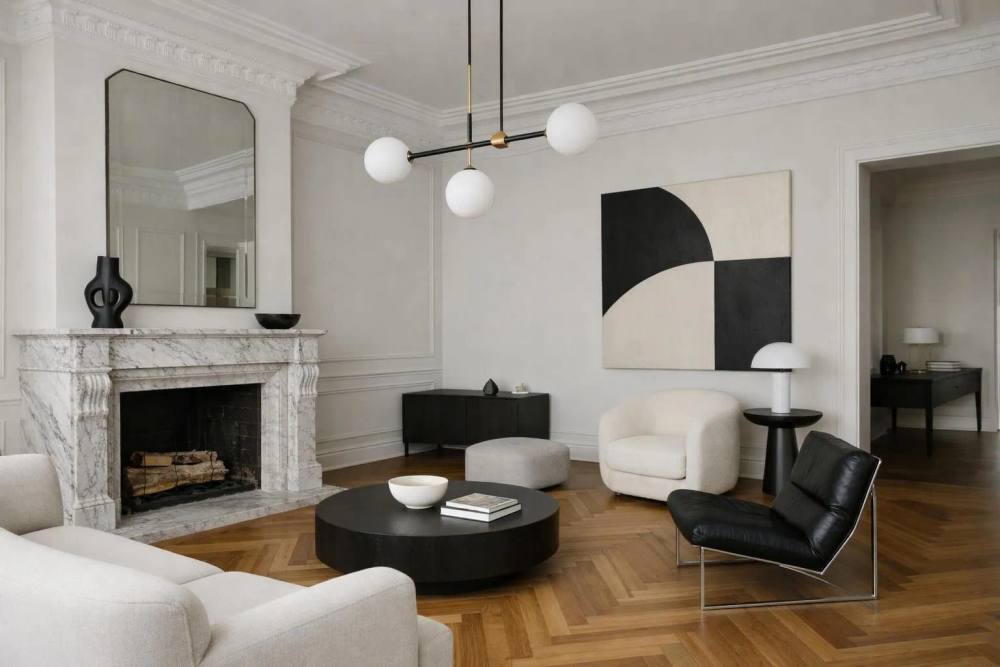 Rénovation d'un appartement de luxe moderne à Genève, avec un salon élégant, parquet chevrons restauré, cheminée en marbre contemporaine, luminaire design et moulures raffinées.