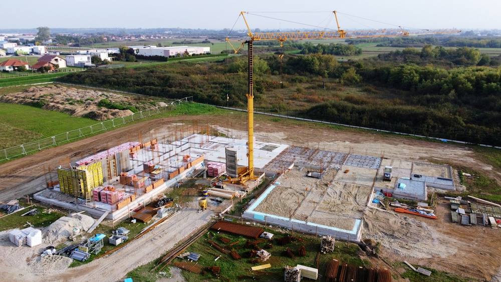 Chantier de construction avec grues, équipements et matériaux.