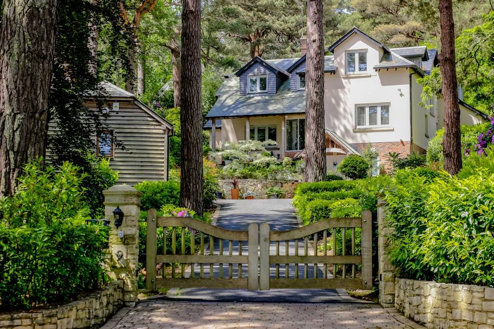 Maison de campagne entourée d'arbres et de végétation luxuriante.
