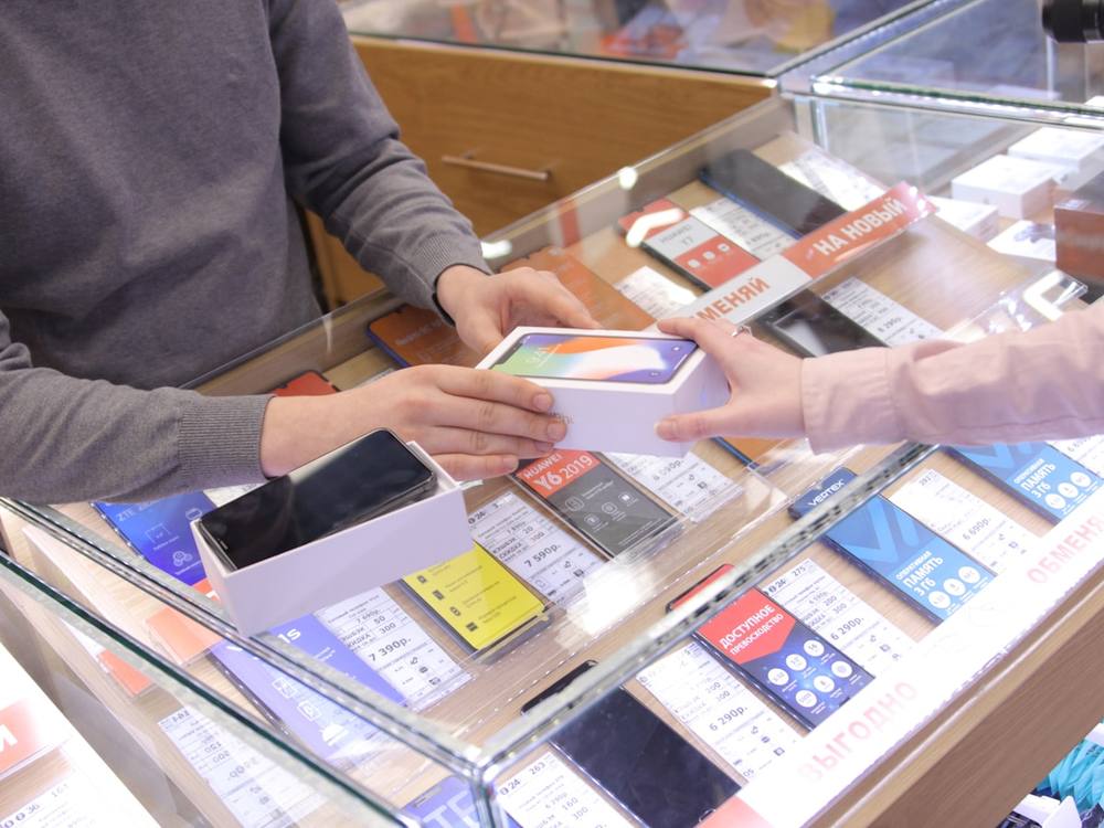 Achat de téléphones portables et d'accessoires électroniques dans un magasin.