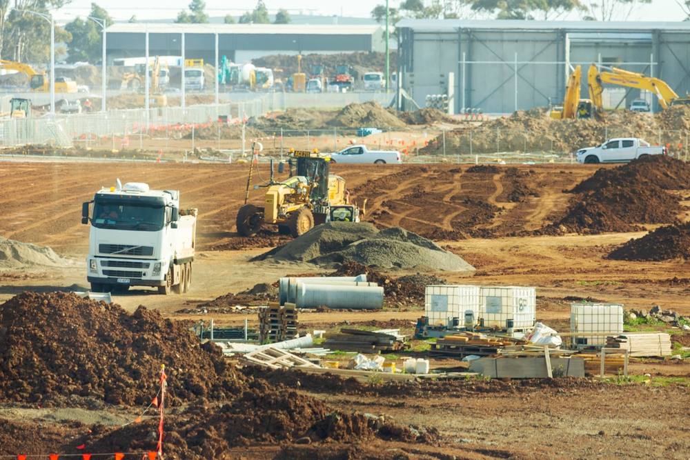 Chantier de construction avec engins de terrassement et camions.
