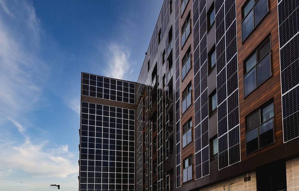 Bâtiment moderne avec panneaux solaires sur la façade.