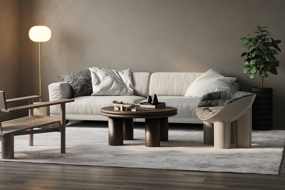 Salon moderne avec canapé blanc, table basse ronde et plante décorative.