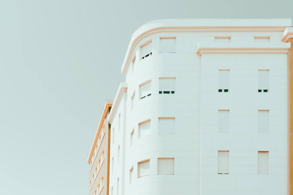 Un grand bâtiment blanc avec une horloge sur le côté.