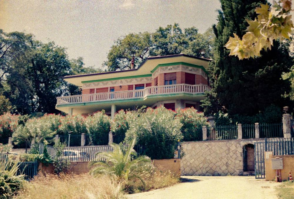 Maison moderne avec balcon entourée de verdure