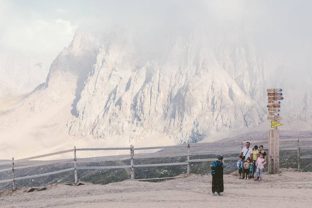 Deux personnes debout près d'une montagne blanche pendant la journée.