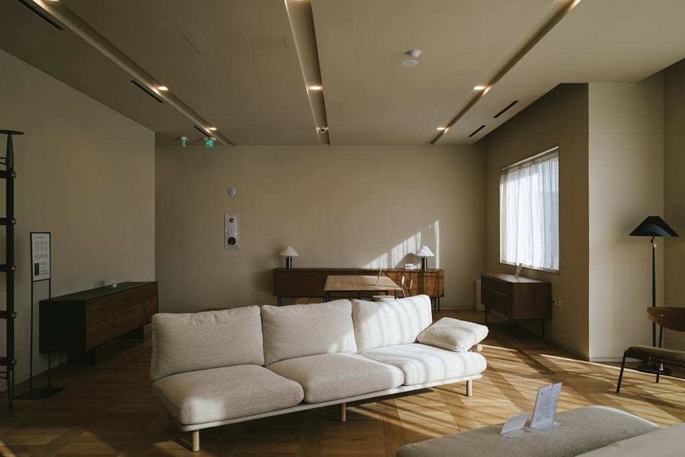 Un canapé blanc assis dans un salon près d'une fenêtre.