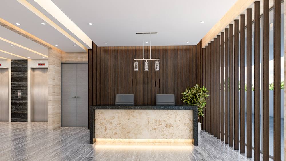 Lobby moderne avec comptoir d'accueil en marbre et mur en bois.