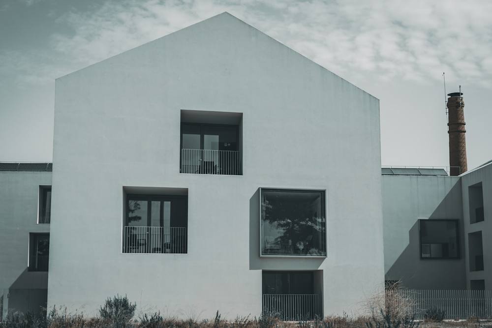 Un bâtiment blanc avec des fenêtres par temps nuageux.